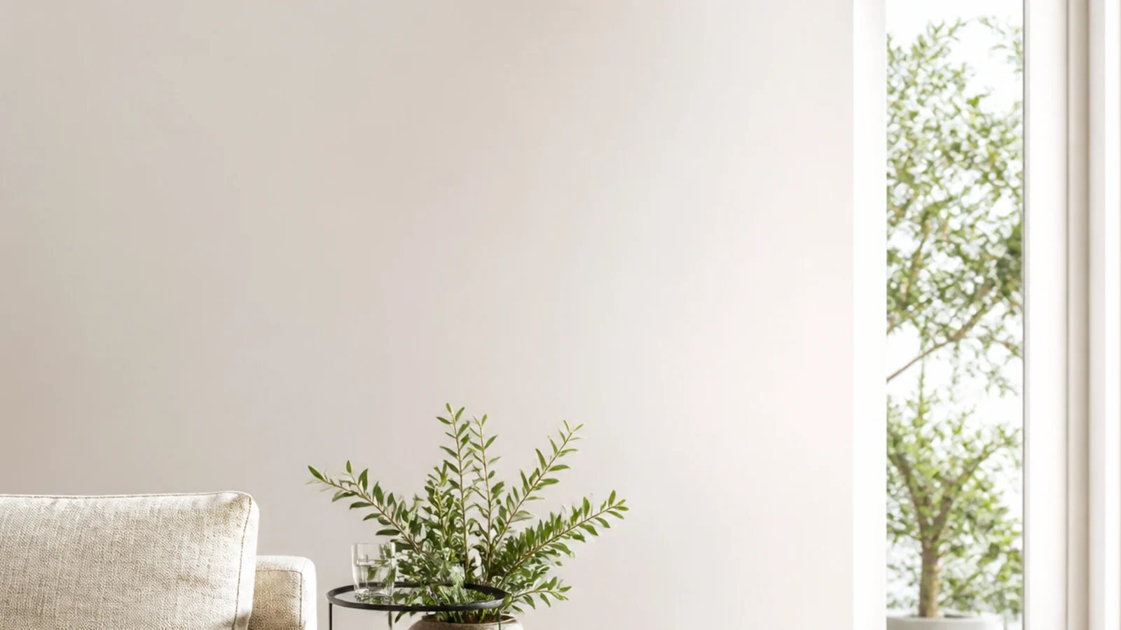 tall view of pale wooden flooring with a jute rug and linen sofa